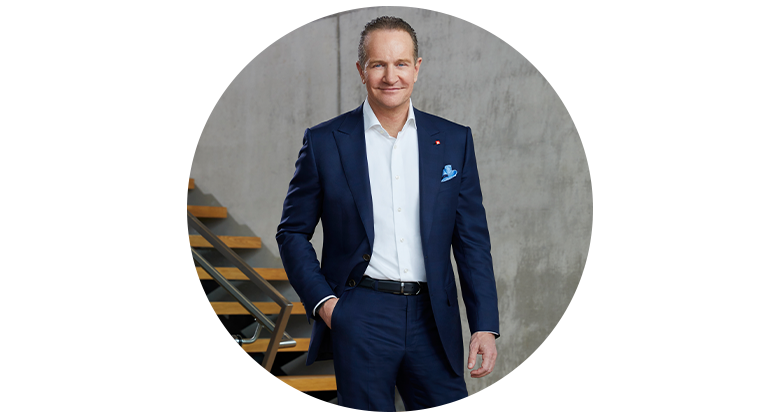 CEO Andreas Kroiss stands in front of the stairs in Einhell World wearing a dark suit.