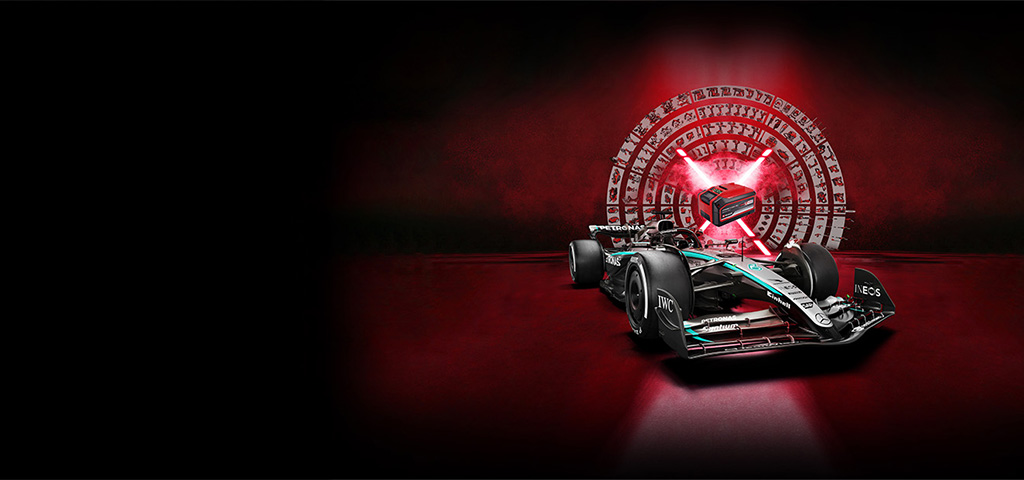 A Formula 1 race car is in the foreground on a dark red background. In the background, a glowing stylized Power X-Change battery is surrounded by a circular array of Einhell tools and icons – symbolizing power, technology, and versatility.