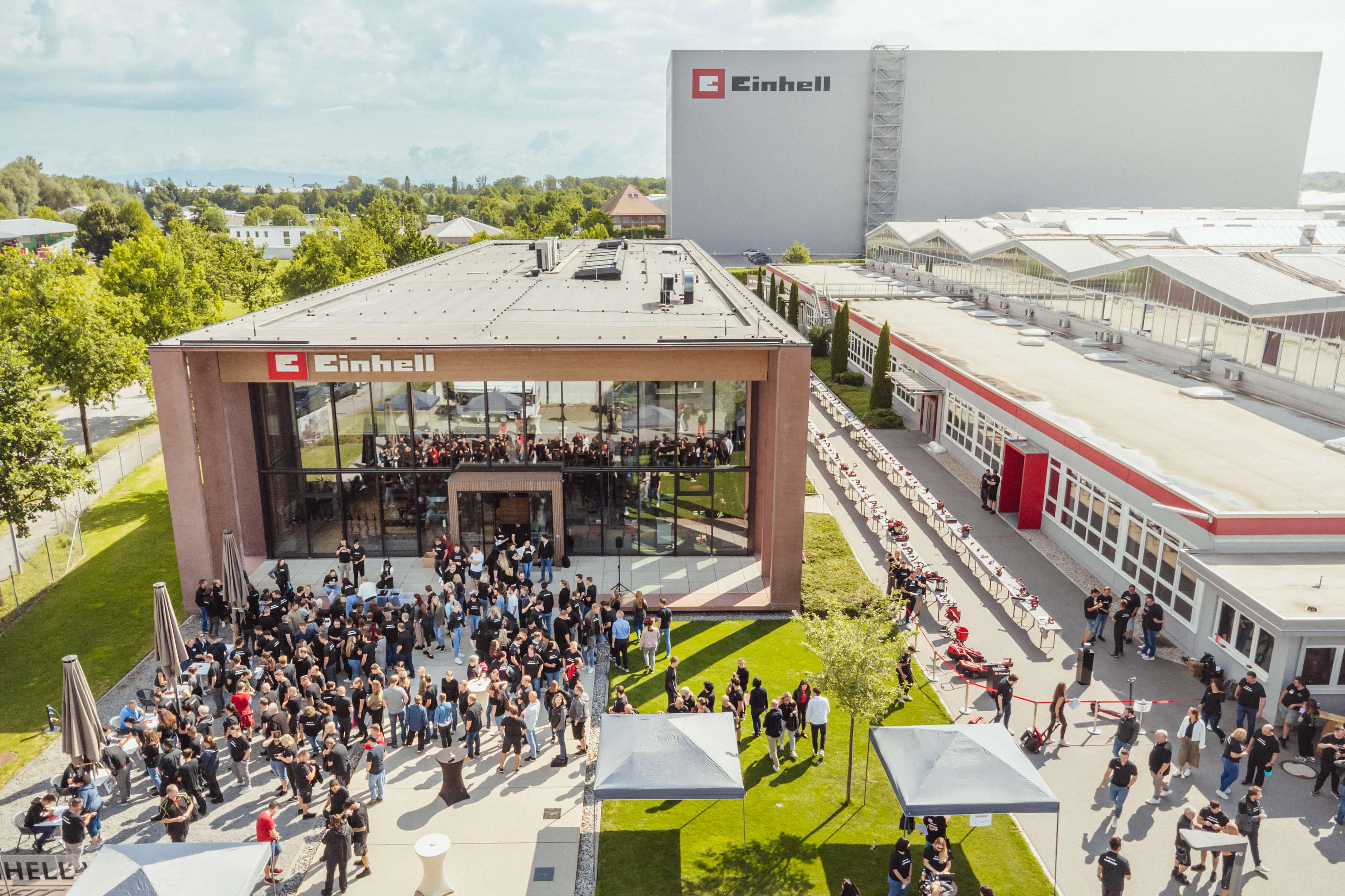 Vista aérea de las instalaciones de Einhell con mucha gente reunida y estaciones de herramientas instaladas.